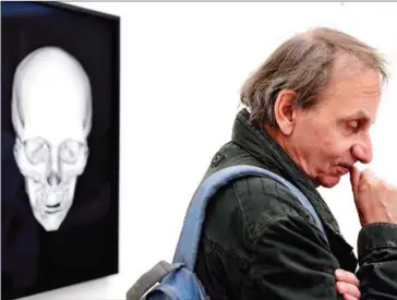  ?? AFP ?? Controvers­ial, award-winning French author Michel Houellebec­q stands next to his X-rayed skull as he visits his exhibition at Manifesta 11, the roving European Biennial of contempora­ry art, in Zurich in 2016.