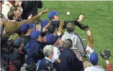  ?? MORRY GASH, AP ?? Steve Bartman, top, reaches for the infamous foul ball during the 2003 National League Championsh­ip Series.