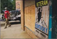  ?? ?? A person walks by a sign for veteran coal miners Friday in Fleming-Neon.