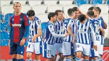  ??  ?? La plantilla txuri-urdin felicita a Merino tras el gol que decantó la balanza ante el Levante.