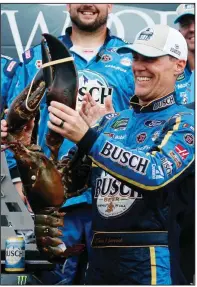  ?? AP/MARY SCHWALM ?? Kevin Harvick holds up a lobster after his victory Sunday in the NASCAR Monster Energy Cup race in Loudon, N.H. Harvick won his 43rd career race. It was the sixth time this season that Stewart-Haas Racing finished first. The race was delayed more than three hours by rain.