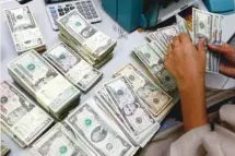  ?? — Reuters ?? A bank employee counts US dollar notes at a Kasikornba­nk in Bangkok, Thailand.