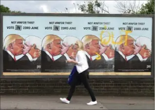  ?? YUI MOK, THE ASSOCIATED PRESS ?? A woman in London walks past EU referendum posters for the pro-Europe group “We Are Europe,” depicting Donald Trump, left on poster, kissing British MP Boris Johnson, who favours leaving the EU.