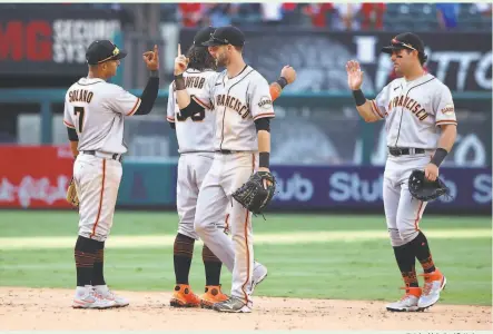  ?? Katelyn Mulcahy / Getty Images ?? Donovan Solano, Brandon Crawford, Steven Duggar and Mike Tauchman celebrate the Giants’ extrainnin­g victory.