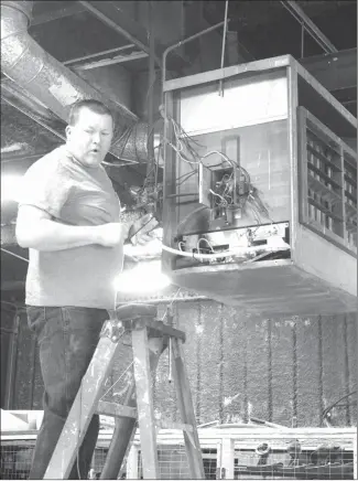  ?? Katie West • Times-Herald ?? Mike Gracey, with Store Services, visits the Forrest City Public Works shop to make a few repairs to the heater. The department has been busy this week filling potholes and cleaning up the former Road Runner property on North Washington.