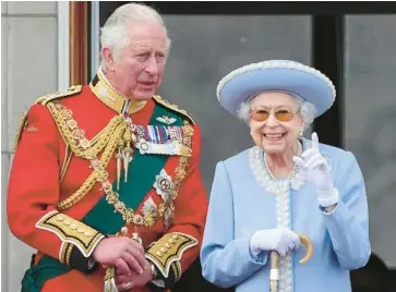  ?? DANIEL LEAL/GETTY-AFP ?? Queen Elizabeth II stands with Prince Charles to watch a special flypast from a balcony at Buckingham Palace following the Queen’s Birthday Parade on June 2.