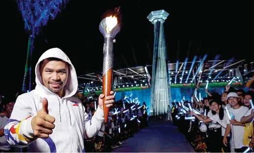  ??  ?? TORCH BEARER – Sen. Manny Pacquiao, the world’s phenomenal boxing champion, carries the lighted torch during a dry run of the 30th Southeast Asian Games parade at the New Clark City in Capas, Tarlac on Nov. 27. Pacquiao will carry the torch signifying the opening of the Games at the Philippine Arena in Bulacan on Saturday. (Contribute­d photo by SAP JJ) Story on Page 17