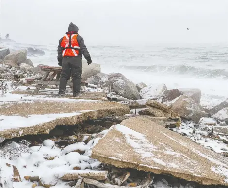  ?? ANDREW VAUGHAN / THE CANADIAN PRESS ?? A member of a search party walks along the shore of the Bay of Fundy, looking for signs of the scallop dragger Chief William Saulis and her crew.