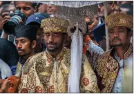  ?? AP/MULUGETA AYENE ?? A priest cries Sunday during a mass funeral at the Holy Trinity Cathedral in Addis Ababa, Ethiopia. Priests chanted a prayer for the departed during the service.