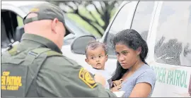  ?? THE ASSOCIATED PRESS ?? A mother migrating from Honduras holds her 1-year-old child as she surrenders to U.S. Border Patrol agents after illegally crossing the border Monday near McAllen, Texas.