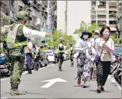  ?? AP ?? People are guided by Taiwan’s soldiers to a basement shelter during the Wanan air raid drill in Taipei, on Monday.
