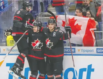  ?? RYAN REMIORZ/THE CANADIAN PRESS ?? Canada’s Connor Mcmichael, centre, is congratula­ted by teammates Liam Foudy, left, and Joe Veleno after scoring to make it 2-0 over Slovakia during Canada’s quarter-final victory.