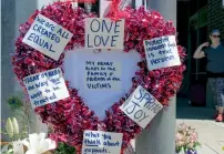  ?? AFP ?? A wreath covered with positive messages hangs on a traffic light pole at a memorial for stabbing victims in Portland. —