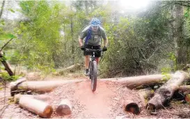  ?? David Hopper ?? Scott Moran of Cypress jumps an obstacle on the bike trails at the 100 Acre Wood Preserve.