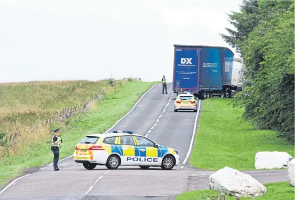  ?? Picture: Gareth Jennings. ?? Police stand guard at a roadblock after the lorry veered off the road during the incident.