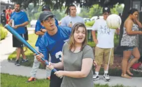  ??  ?? Colorado Center for the Blind student-athlete Cheyenne Argys gets guidance from Jimmy Peng of the National Beep Baseball Associatio­n. Andy Cross, The Denver Post