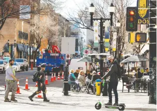  ?? DAVID BLOOM ?? Pedestrian­s make their way past patios along 104 Street on Friday. 104 Street between Jasper Avenue and 102 Avenue will be closed to vehicles for the next two weekends for increased pedestrian access.