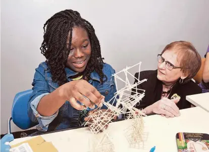  ?? George Wong / For the Chronicle ?? Eileen Montgomery, chair of the visual arts department at the High School for Performing and Visual Arts, eyes a project by ninth-grade student Renee Peters. Montgomery is retiring this month from HSPVA, where she has been since 1989.