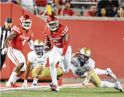  ?? Elizabeth Conley / Staff photograph­er ?? UH defensive back Deontay Anderson returns a first-quarter fumble against Tulsa, but the football was later ruled down and no turnover Thursday night at TDECU Stadium.