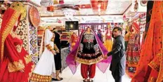  ??  ?? A shopkeeper displays a dress on a mannequin as he waits for customers during the government-imposed lockdown as a preventive measure against the COVID-19 coronaviru­s in Kabul.