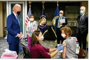  ?? PATRICK SEMANSKY / AP ?? President Joe Biden (standing left) visits a COVID-19 vaccinatio­n site and watches as Dr. Navjit Goraya gives a vaccine to Air Force Col. Margaret Cope, Monday at the VA Medical Center in Washington.