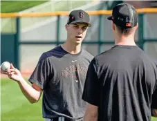  ?? MORRY GASH/AP ?? The Giants’ Tyler Rogers talks to his twin brother, Taylor, during a spring training workout.