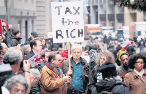  ?? /GETTY IMAGES ?? Manifestan­tes se reunieron ayer para protestar contra la aprobación de la reforma fiscal impulsada por el presidente Donald Trump en el distrito financiero de Nueva York.