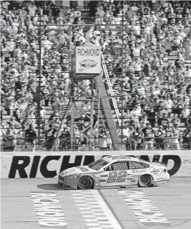  ?? [AP PHOTO] ?? Joey Logano takes the checkered flag to win the NASCAR Cup Series race Sunday at Richmond Internatio­nal Raceway in Richmond, Va.