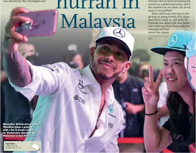  ??  ?? Mercedes’ British driver Lewis Hamilton takes a picture with a fan in Kuala Lumpur on Wednesday ahead of the Malaysian Grand Prix.