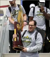  ?? Associated Press ?? Scott Drew carries the national championsh­ip trophy off the plane Tuesday as Baylor arrived home in Waco, Texas, after its title run in Indianapol­is.