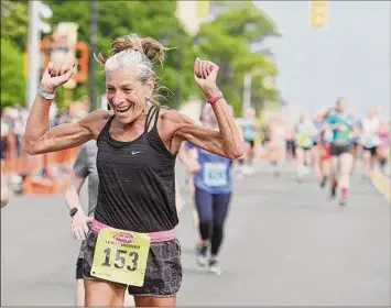  ?? Times Union archive ?? Denise Herman of Saratoga Springs celebrates as she crosses the finish line during the Freihofer's Run for Women in 2019 in Albany.