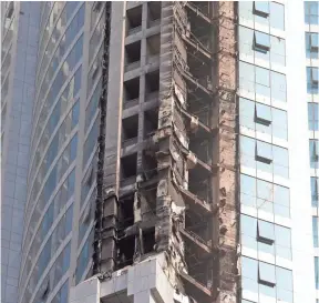  ?? KARIM SAHIB, AFP/GETTY IMAGES ?? Fire damaged the 1,100-foot Torch Tower in Dubai on Friday. It was the second blaze to hit the skyscraper. An inferno in 2015 caused extensive damage to its luxury flats and triggered an evacuation of nearby blocks in the Marina neighborho­od.