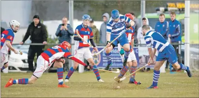  ??  ?? Newtonmore’s Ewan Fraser jumps out of the way as Kingussie’s Alexander Michie and Newtonmore’s Evan Menzies start swinging.