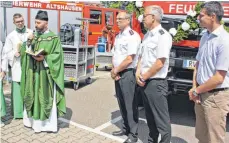  ?? FOTO: ARTUR K.M. BAY ?? Pfarrer Christof Mayer segnet die beiden Fahrzeuge der Altshauser Feuerwehr, worüber sich Kommandant Hermann Fink, Kreisbrand­meister Oliver Surbeck und Bürgermeis­ter Patrick Bauser freuen.