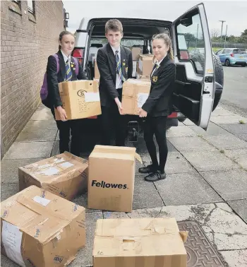  ??  ?? Beth Laybourne, head girl, Euan Parker, head boy, and Niamh Dawson, deputy head girl, of Hetton School helping to load books for shipment to Africa as part of Book Aid Africa.