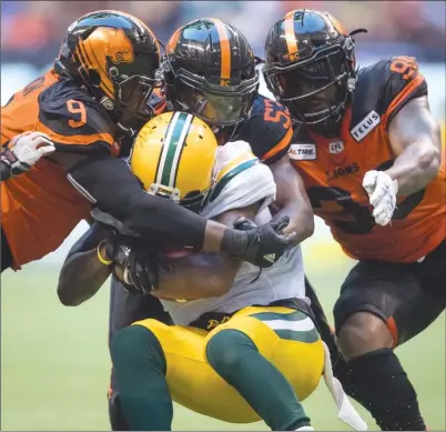  ?? The Canadian Press ?? B.C. Lions defenders Shawn Lemon, back left to right, Jordan Herdman and Davon Coleman tackle Edmonton Eskimos’ C.J. Gable duringfirs­t-halfCFLact­ioninVanco­uveronThur­sdaynight.TheLionswo­n31-23.