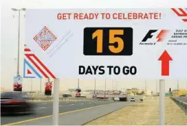  ??  ?? Countdown to GP: Motorists passing a sign in Hamad Town promoting the Formula One Bahrain grand prix. — AFP