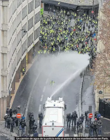  ??  ?? Un camión de agua de la policía evita el avance de los manifestan­tes en París.