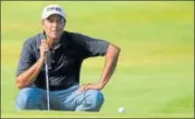  ?? GETTY IMAGES ?? ▪ Arjun Atwal lines a putt on the 18th green.