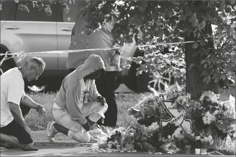  ?? MATT ROURKE/AP ?? PEOPLE PAY THEIR RESPECTS SUNDAY OUTSIDE THE SCENE of a shooting at a supermarke­t in Buffalo, N.Y., on Saturday.