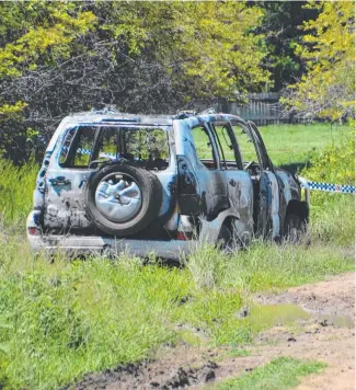  ?? DESTROYED: The stolen car which was burnt in bushland near Rasmussen yesterday. ??