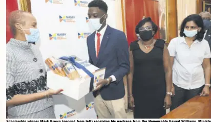  ??  ?? Scholarshi­p winner Mark Brown (second from left) receiving his package from the Honourable Fayval Williams, Minister of Education, Youth and Informatio­n as Winsome Gibbs, Branch Manager, Dr. Nagarani Ponakala – Head of Math Department and Pro-vice Chancellor and Principal, Professor Dale Weber of UWI Mona Campus look on.