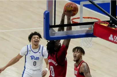  ?? Associated Press ?? North Carolina State’s DJ Funderburk dunks as Pitt’s Ithiel Horton, left, watches in the Wolfpack’s 74-73 win Wednesday night at Petersen Events Center.