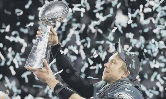  ??  ?? 2 Philadelph­ia Eagles’ Nick Foles holds up the Vince Lombardi Trophy after Super Bowl 52 in which his team defeated the New England Patriots.