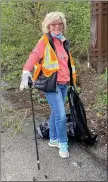  ??  ?? Carmel Stone finds plenty of litter to fill her trash bag along Old Line Road.