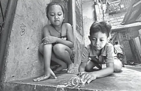  ?? MACKY LIM ?? KID’S GAMES. Children play rubber bands outside their house in Barangay 39-D in Davao City during their free time before studying their lessons.