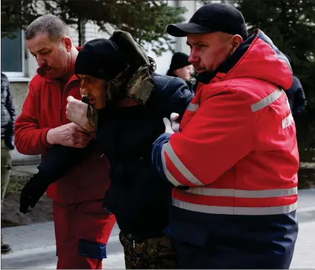  ?? Picture: Dan Kitwood/getty ?? An injured man is assisted by medical staff as he arrives at hospital after the attack at the training base near Lviv, Ukraine
