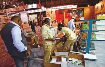  ?? Atiq Ur Rehman/Gulf News ?? ■ Workers unloading boxes of books at Sharjah Expo Centre.