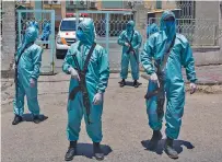  ?? KHALIL HAMRA/ASSOCIATED PRESS ?? Palestinia­n Hamas police officers wear protective suits as they take part Saturday in a simulation of coronaviru­s infections in Gaza City.