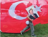  ??  ?? Podpornik vladajoče Stranke pravičnost­i in razvoja (AKP) s portretom turškega predsednik­a Recepa Tayyipa Erdoğana